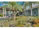 Beautiful clubhouse exterior with covered entry, seating, and lush landscaping at 1318 Red Oak Ln, Port Charlotte, FL 33948