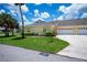 Side view of the home showing the attached garage, manicured lawn, and walkway to the front entrance at 1318 Red Oak Ln, Port Charlotte, FL 33948