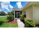 Landscaped front entrance featuring a charming screened porch for relaxing and enjoying the outdoors at 1318 Red Oak Ln, Port Charlotte, FL 33948