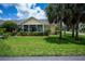Charming home with a well-manicured lawn, lush landscaping, and inviting front porch with column supports at 1318 Red Oak Ln, Port Charlotte, FL 33948