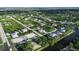 Aerial view of a house in a residential area surrounded by lush greenery, near a river at 13406 Chenille Dr, Port Charlotte, FL 33981