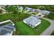 Aerial shot of a home's backyard and lush lawn, including a covered lanai and small palm trees at 13406 Chenille Dr, Port Charlotte, FL 33981