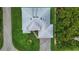 Top-down aerial view of a home with a gray roof, green lawn, and a paved driveway and walkway at 13406 Chenille Dr, Port Charlotte, FL 33981