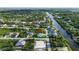 Aerial view showing the property's location in a neighborhood near a canal and surrounding greenery at 13406 Chenille Dr, Port Charlotte, FL 33981