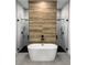 Luxurious bathroom with freestanding tub, dual walk-in showers, and stylish wood accent wall at 13406 Chenille Dr, Port Charlotte, FL 33981