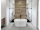 Luxurious bathroom featuring a freestanding tub and dual walk-in showers with wood accent wall at 13406 Chenille Dr, Port Charlotte, FL 33981