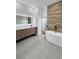 Modern bathroom with a sleek vanity, dual sinks, a freestanding tub, and a walk-in shower at 13406 Chenille Dr, Port Charlotte, FL 33981