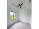 Bright bedroom with a ceiling fan and large window offering pleasant views at 13406 Chenille Dr, Port Charlotte, FL 33981