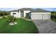 Charming home with well-manicured lawn, palm trees, and a spacious driveway leading to a two-car garage at 13406 Chenille Dr, Port Charlotte, FL 33981