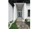 Modern front door, with stylish stonework and lighting creating a welcoming entrance to the home at 13406 Chenille Dr, Port Charlotte, FL 33981