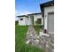 Modern home featuring a neatly landscaped yard, stone walkway, and neutral color palette at 13406 Chenille Dr, Port Charlotte, FL 33981