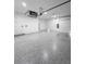 Clean two car garage with epoxy flooring, white walls and a door leading to inside the home at 13406 Chenille Dr, Port Charlotte, FL 33981