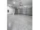 Spacious two car garage with epoxy flooring, two garage door openers, and white walls at 13406 Chenille Dr, Port Charlotte, FL 33981