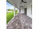 Long covered outdoor patio with paver flooring, ceiling fans and views of the green yard at 13406 Chenille Dr, Port Charlotte, FL 33981
