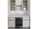 Stylish wet bar with glass-front cabinets and built-in wine cooler for entertaining at 13406 Chenille Dr, Port Charlotte, FL 33981