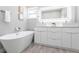 The stunning bathroom features a soaking tub and a double vanity with a sleek design at 14372 Tugwell Ave, Port Charlotte, FL 33953