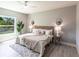 Serene main bedroom with light gray walls, ceiling fan, light accents, and plank flooring at 14372 Tugwell Ave, Port Charlotte, FL 33953