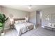 Serene main bedroom with light gray walls, ceiling fan, a bathroom ensuite, and plank flooring at 14372 Tugwell Ave, Port Charlotte, FL 33953