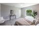 Serene main bedroom with light gray walls, accent table, a view to the yard, and plank flooring at 14372 Tugwell Ave, Port Charlotte, FL 33953