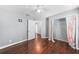 Bedroom with dark wood floors, ceiling fan, and closet with patterned curtains at 1523 Napoleon Rd, North Port, FL 34288