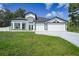Inviting front exterior of home with a well-manicured lawn and a three-car garage at 1523 Napoleon Rd, North Port, FL 34288