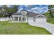 Beautiful home with a fresh green lawn and attractive curb appeal, showcasing a three-car garage at 1523 Napoleon Rd, North Port, FL 34288