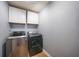 Laundry room featuring a side-by-side stainless steel washer and dryer and overhead cabinets at 1523 Napoleon Rd, North Port, FL 34288