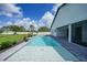 Backyard pool with a paved patio area, lush landscaping, and a privacy fence at 1523 Napoleon Rd, North Port, FL 34288