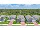 Aerial view of the neighborhood with well-maintained houses, driveways, lawns, and green trees in the backdrop at 15261 Mille Fiore Blvd, Port Charlotte, FL 33953