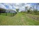 Picturesque backyard with a black fence, offering privacy and views of the surrounding green space and drainage canal at 15261 Mille Fiore Blvd, Port Charlotte, FL 33953