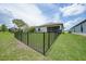 A view of the backyard that is fenced in and leads to a screened-in porch and shows the proximity to the other houses at 15261 Mille Fiore Blvd, Port Charlotte, FL 33953