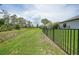 Picturesque backyard with a black fence, offering privacy and views of the surrounding green space and neighboring houses at 15261 Mille Fiore Blvd, Port Charlotte, FL 33953