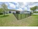 A view of the backyard that is fenced in and leads to a screened-in porch and shows the proximity to the other houses at 15261 Mille Fiore Blvd, Port Charlotte, FL 33953