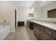 Spacious bathroom with dual vanity sinks, granite countertops, and a separate bathtub at 15261 Mille Fiore Blvd, Port Charlotte, FL 33953