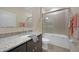 Well-lit bathroom featuring a vanity with granite countertops and a shower-tub combo at 15261 Mille Fiore Blvd, Port Charlotte, FL 33953