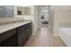 Modern bathroom featuring wood-like tile, granite countertops, and a shower and bath combo at 15261 Mille Fiore Blvd, Port Charlotte, FL 33953