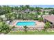 Aerial view of a community pool with lounge chairs and lush tropical landscaping at 15261 Mille Fiore Blvd, Port Charlotte, FL 33953