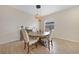 Cozy dining area with a round table, upholstered chairs, and a modern chandelier at 15261 Mille Fiore Blvd, Port Charlotte, FL 33953