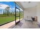 This cozy lanai features comfortable seating, a table, tile flooring, and views of the backyard and lush greenery beyond at 15261 Mille Fiore Blvd, Port Charlotte, FL 33953