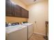 Functional laundry room with dark cabinets, washer, dryer, and convenient storage at 15261 Mille Fiore Blvd, Port Charlotte, FL 33953