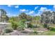 Tranquil backyard oasis with a white gazebo, lush greenery, and a serene pond view, creating a private retreat at 15652 Havana Cir, Port Charlotte, FL 33981