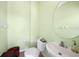 Cozy half bath with a round mirror, toilet, and sink at 15652 Havana Cir, Port Charlotte, FL 33981