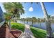 Paver path leads to a private wooden dock on a canal with lush landscaping at 15652 Havana Cir, Port Charlotte, FL 33981