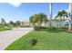 Well-maintained home featuring lush landscaping, mature palm trees, and a paved driveway, reflecting curb appeal at 15652 Havana Cir, Port Charlotte, FL 33981