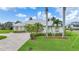 Beautiful single-story home featuring lush tropical landscaping, a brick driveway, and a metal roof at 15652 Havana Cir, Port Charlotte, FL 33981