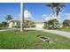 Charming single-story home with a well-manicured lawn, mature palm trees, and a welcoming paved driveway at 15652 Havana Cir, Port Charlotte, FL 33981