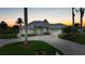 A beautiful sunset highlights the lush landscaping, brick driveway, and metal roof of this home at 15652 Havana Cir, Port Charlotte, FL 33981