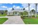 Charming home featuring mature tropical landscaping, a brick driveway, and a metal roof at 15652 Havana Cir, Port Charlotte, FL 33981