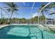 Beautiful screened-in pool and hot tub with canal views and tropical landscaping at 15652 Havana Cir, Port Charlotte, FL 33981