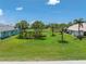 Aerial view of a large, grassy property with palm trees and surrounding neighborhood homes at 167 & 169 Marker Rd, Rotonda West, FL 33947
